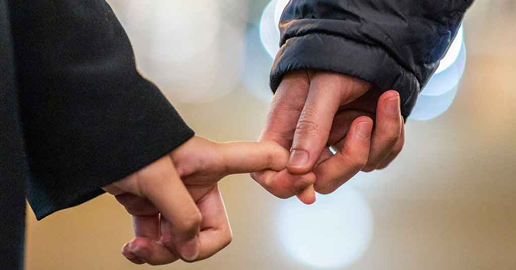 two people holding fingers-signs of relationship compatibility
