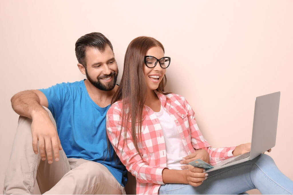 Man and Women smiling with a computer
