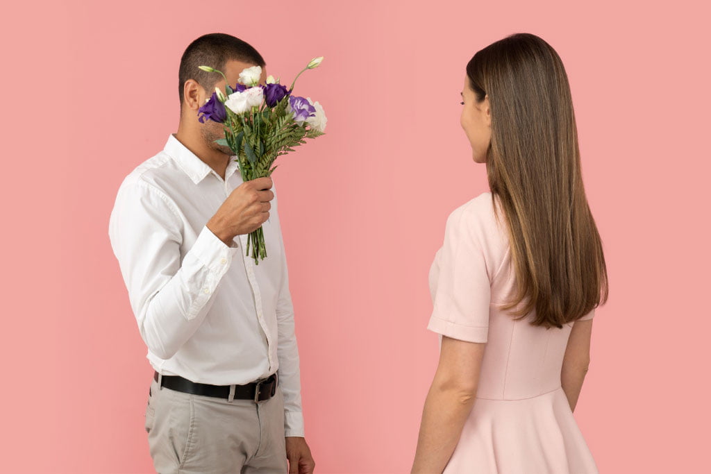 Man presenting flower to a women
