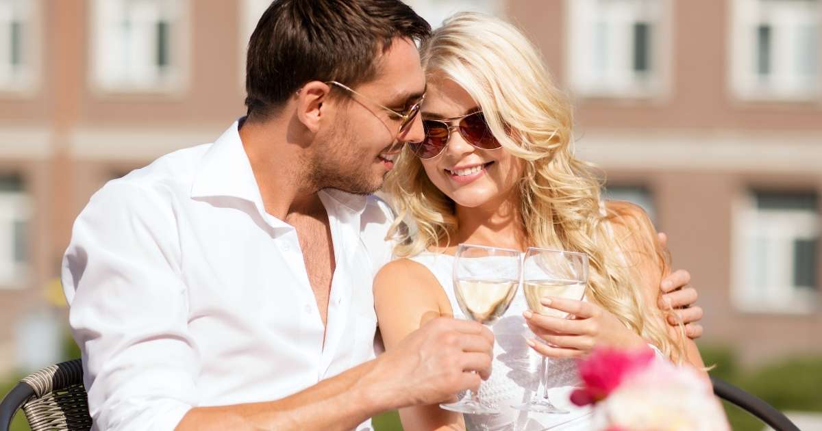 A couple is sitting in the café and drinking wine