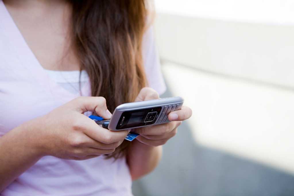 Young woman sending a text message