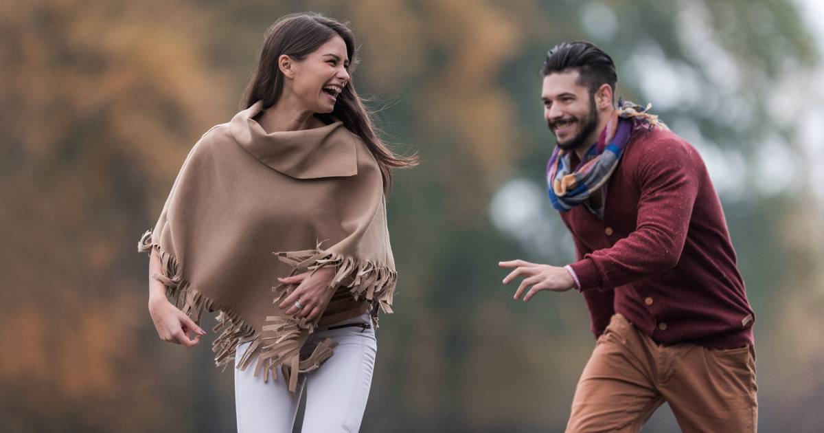 Young beautiful woman having fun while being chased by her boyfriend
