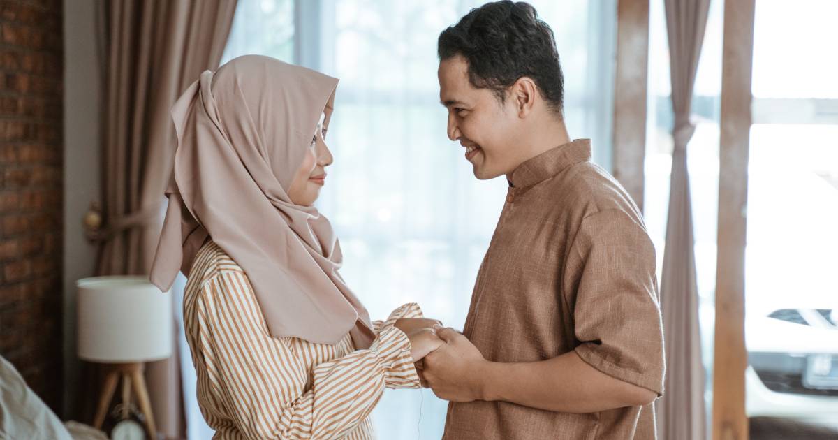 A couple holding hands and smiling at each other