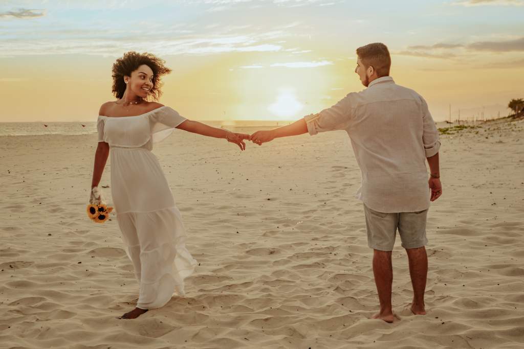 Image showing a couple holding hands while standing far apart, depicting a long-distance relationship.