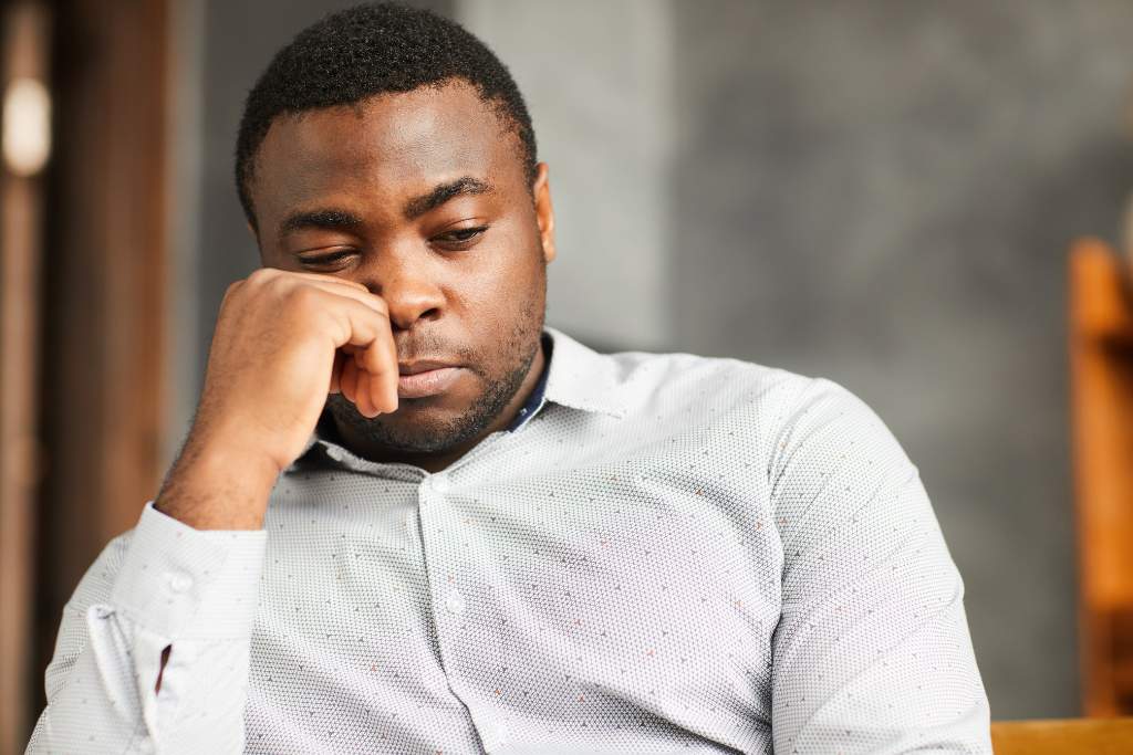 Image showing a man sitting alone and looking sad, missing his partner.