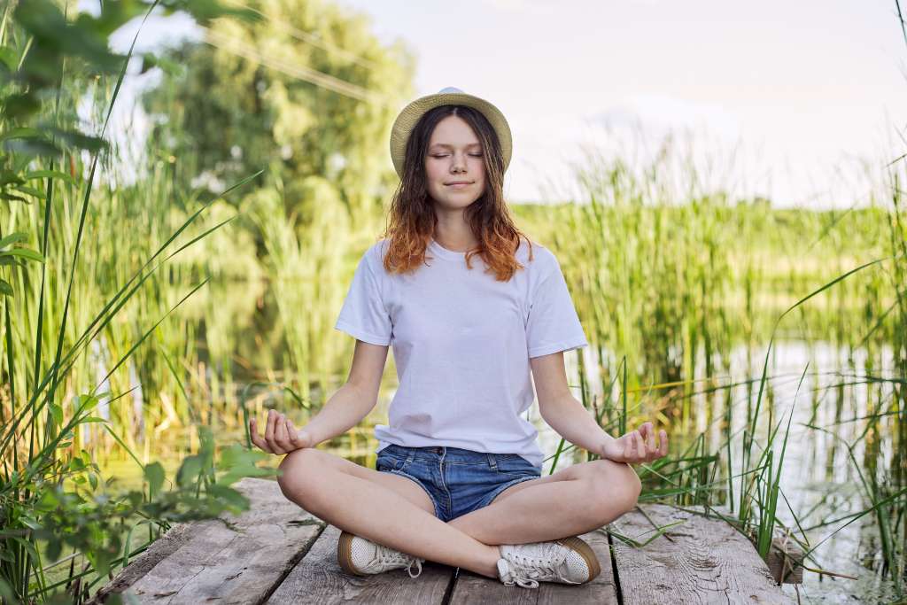 A person meditating outdoors in a peaceful natural setting, representing the importance of self-care in maintaining a healthy and fulfilling relationship, as discussed in this section of the article.