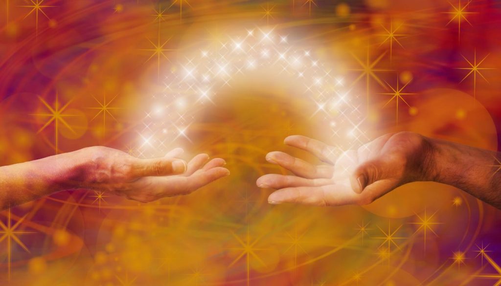 Two hands reaching out, bathed in a warm, radiant light, symbolizing connection and unity.